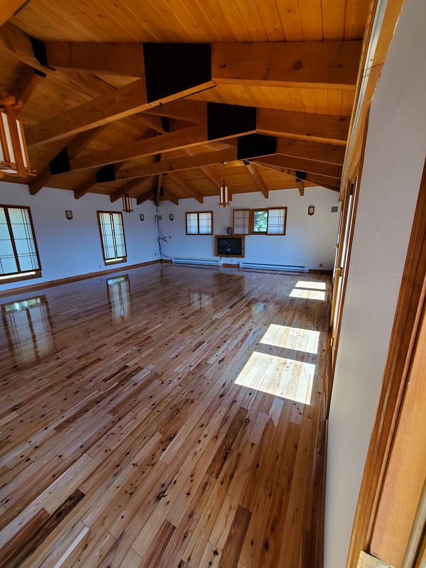 Australian Cypress flooring with natural finish in large room with vaulted rafters